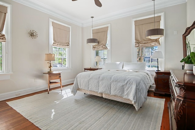 bedroom featuring ornamental molding, dark wood-type flooring, and ceiling fan