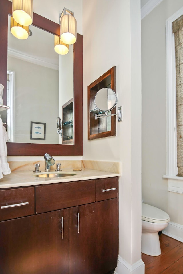 bathroom with crown molding, vanity, toilet, and hardwood / wood-style floors