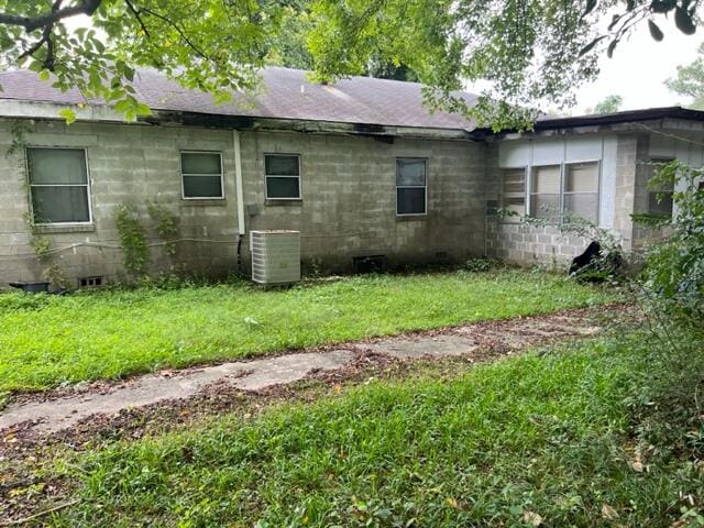 view of property exterior with central air condition unit and a yard