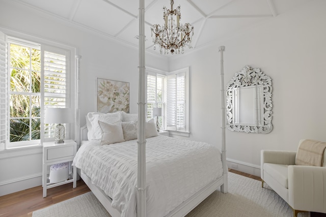 bedroom with hardwood / wood-style flooring and an inviting chandelier