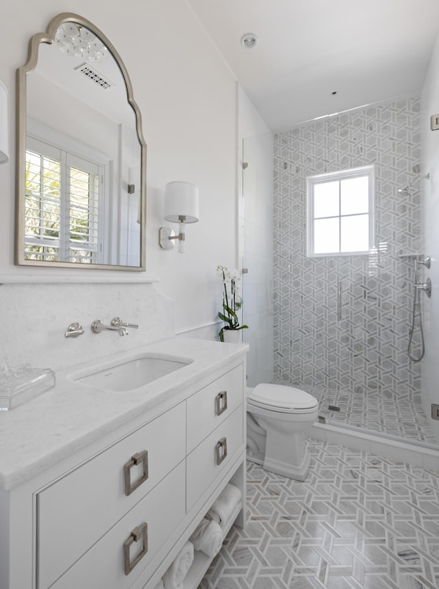 bathroom featuring vanity, an enclosed shower, and toilet