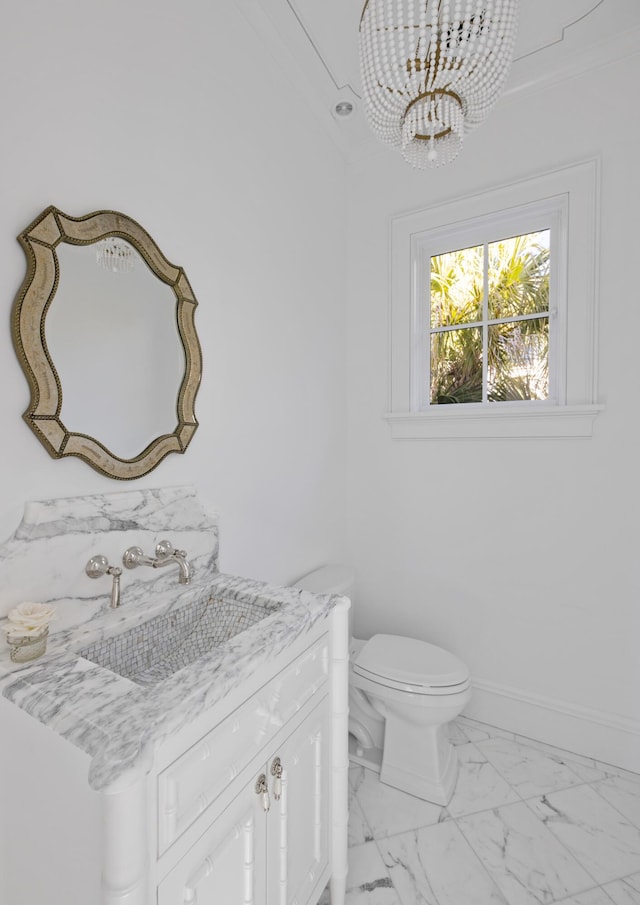 bathroom with vanity, a notable chandelier, and toilet