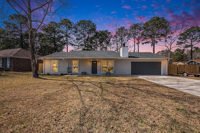 ranch-style house featuring an attached garage, concrete driveway, and a chimney