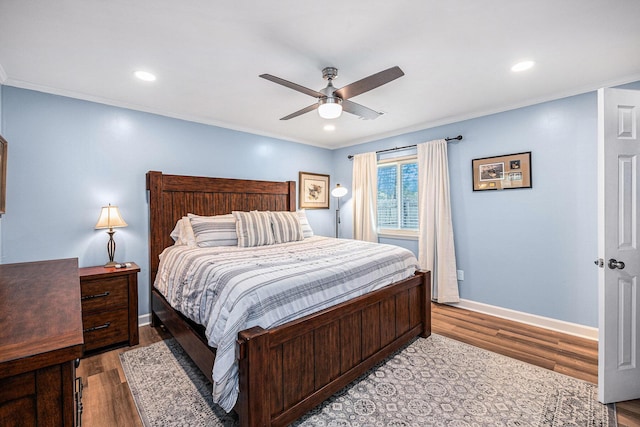 bedroom featuring wood finished floors, baseboards, crown molding, ceiling fan, and recessed lighting