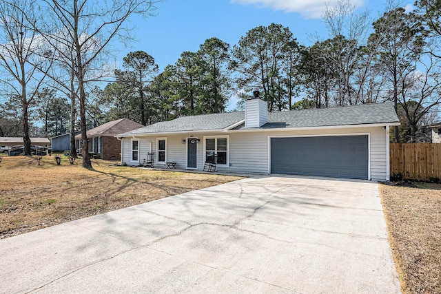 ranch-style home with driveway, a garage, a chimney, and a shingled roof