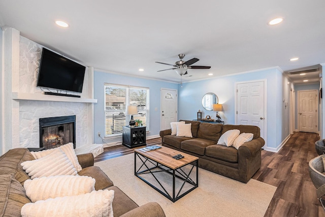 living room featuring dark wood-type flooring, baseboards, a ceiling fan, crown molding, and recessed lighting