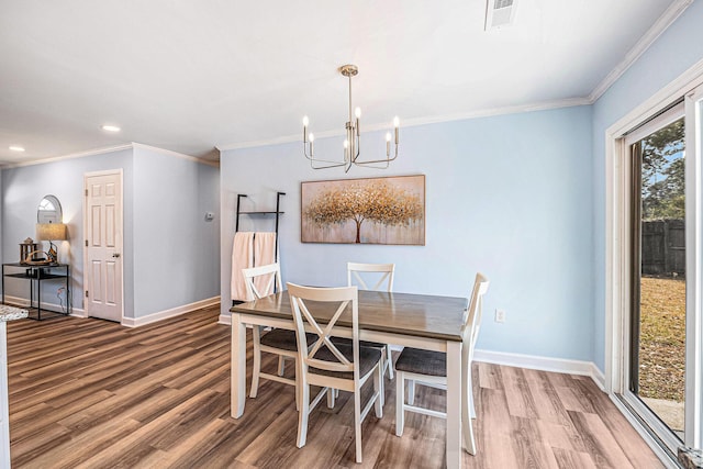 dining room with wood finished floors, a chandelier, baseboards, recessed lighting, and ornamental molding