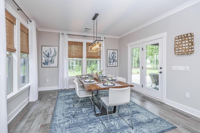 dining space with dark hardwood / wood-style flooring, ornamental molding, and a chandelier