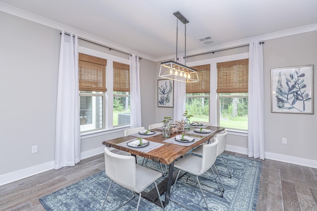 dining room with crown molding and dark hardwood / wood-style floors