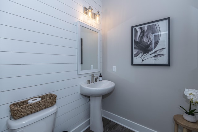 bathroom with hardwood / wood-style floors, toilet, and sink