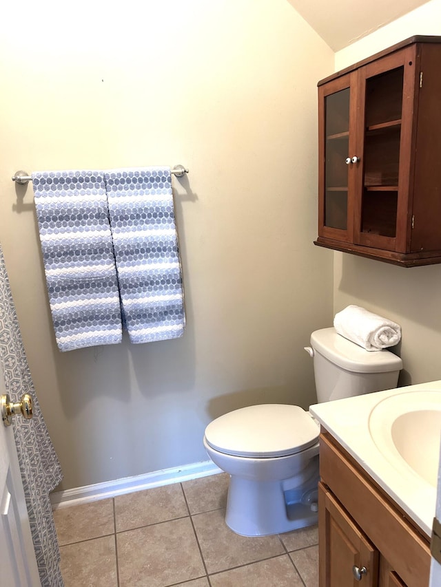 bathroom with baseboards, vanity, toilet, and tile patterned floors