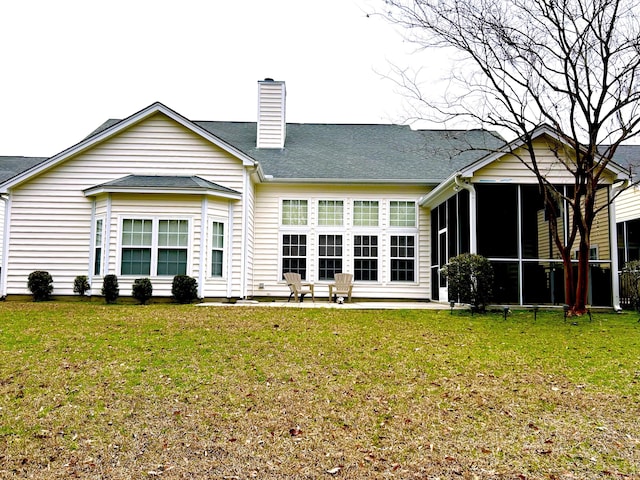 back of house featuring a sunroom, a yard, and a chimney