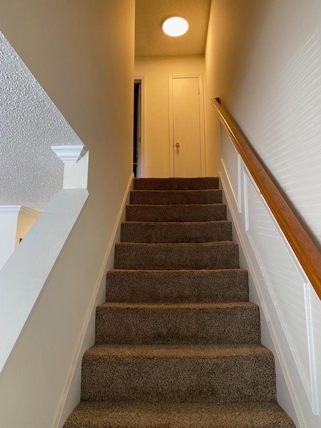 staircase featuring carpet flooring