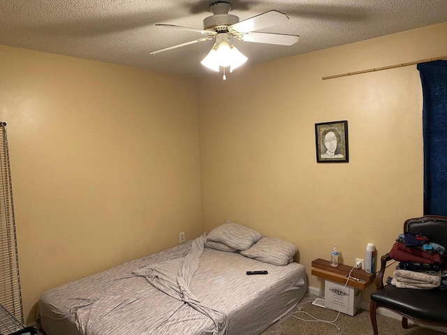 carpeted bedroom with a textured ceiling and ceiling fan