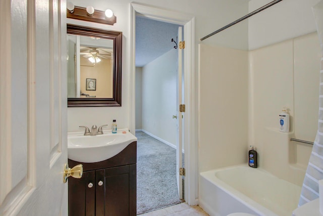 bathroom with shower / bathtub combination with curtain, vanity, and ceiling fan