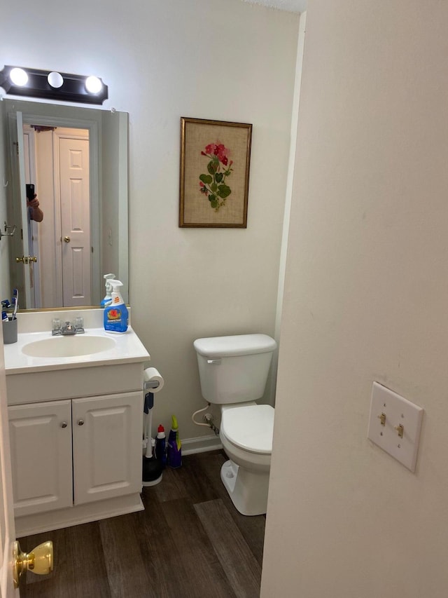 bathroom with wood-type flooring, vanity, and toilet