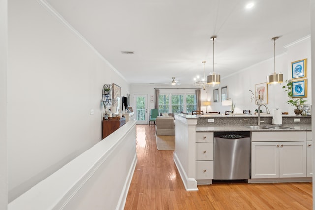 kitchen with pendant lighting, white cabinetry, sink, stainless steel dishwasher, and light hardwood / wood-style floors