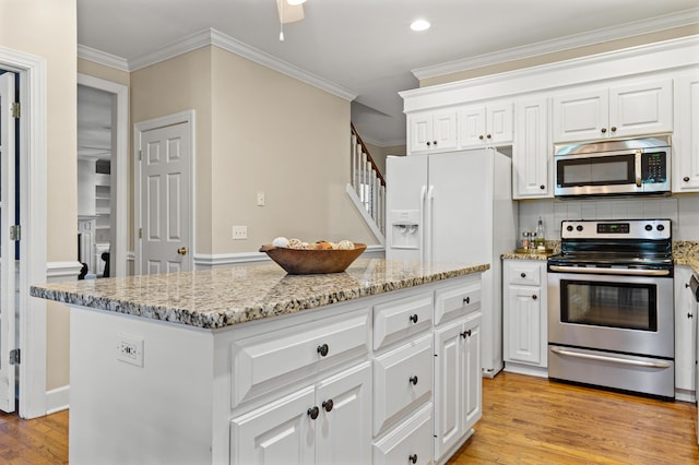 1096 Dunham Rd, Orangeburg, SC 29118 - kitchen featuring light stone counters, light wood finished floors, white cabinetry, crown molding, and appliances with stainless steel finishes