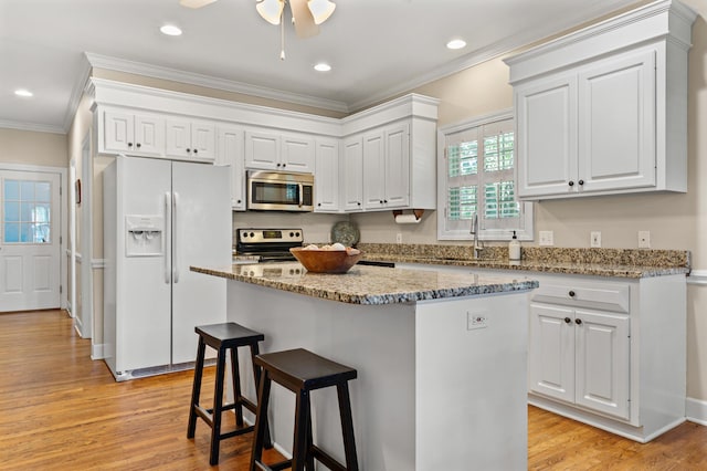 1096 Dunham Rd, Orangeburg, SC 29118 - kitchen featuring a breakfast bar, a sink, white cabinetry, crown molding, and appliances with stainless steel finishes
