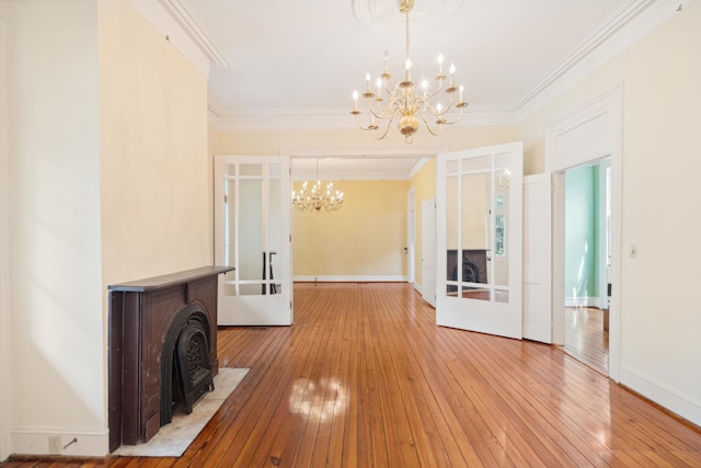 hallway with an inviting chandelier, crown molding, and light hardwood / wood-style floors