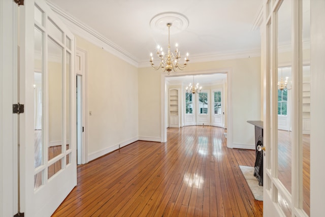 interior space with french doors, hardwood / wood-style floors, a chandelier, and ornamental molding