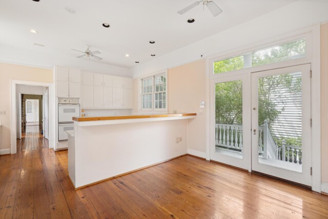 kitchen featuring white cabinetry, light hardwood / wood-style floors, and ceiling fan