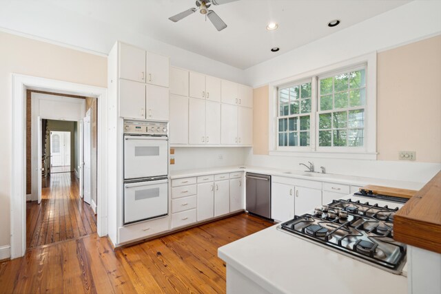 kitchen featuring appliances with stainless steel finishes, light wood-type flooring, and white cabinetry