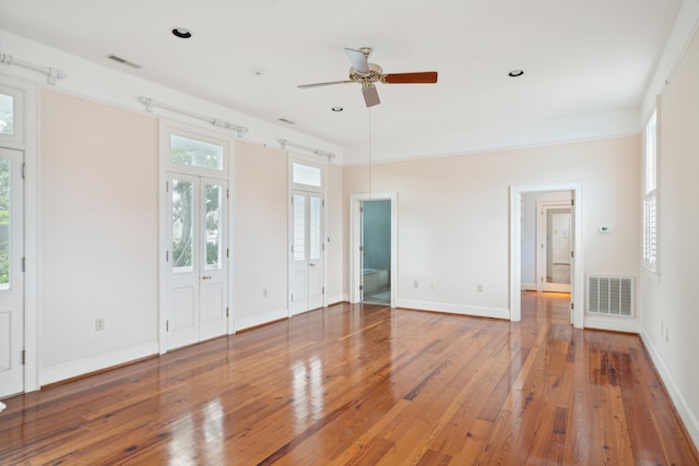 unfurnished bedroom featuring ensuite bathroom, hardwood / wood-style flooring, and ceiling fan