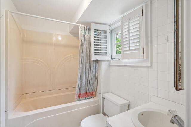 full bathroom featuring vanity, toilet, shower / tub combo, and tile walls