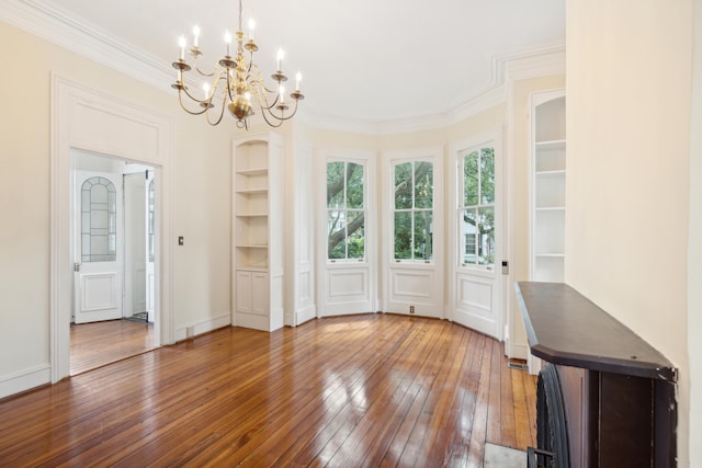 interior space with wood-type flooring, crown molding, and a chandelier