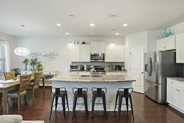 310 Silent Bluff Dr, Summerville, SC 29486 - kitchen with stainless steel appliances, hanging light fixtures, a kitchen island with sink, and white cabinets