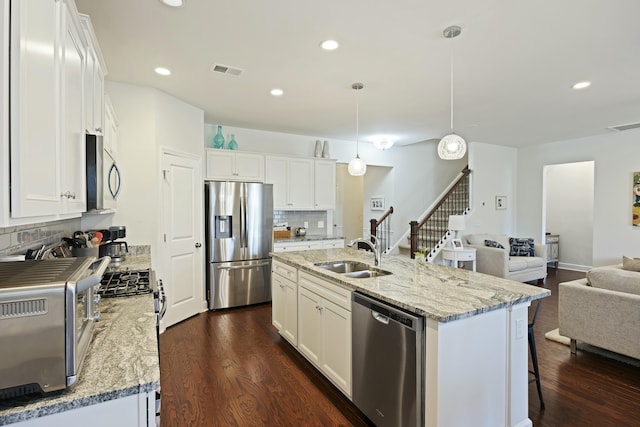 310 Silent Bluff Dr, Summerville, SC 29486 - kitchen featuring an island with sink, hanging light fixtures, stainless steel appliances, white cabinetry, and a sink