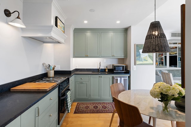 kitchen featuring dark countertops, light wood-style floors, stainless steel microwave, black electric range, and a sink