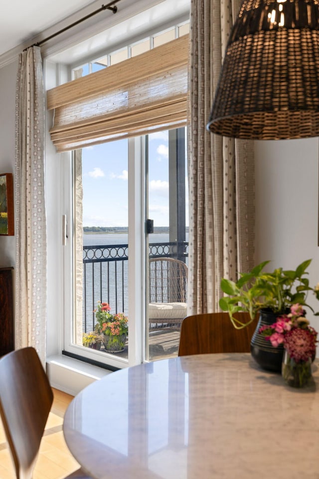 dining space featuring crown molding and a water view