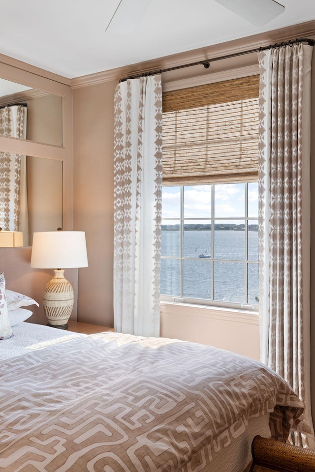 bedroom featuring a water view and ornamental molding