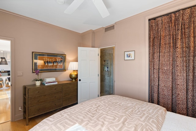bedroom featuring visible vents, ornamental molding, a ceiling fan, and wood finished floors