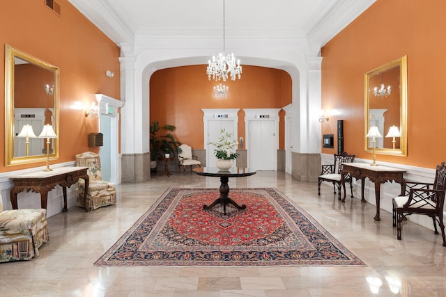 foyer entrance with crown molding, arched walkways, a chandelier, marble finish floor, and visible vents
