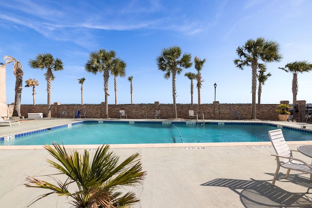 community pool with fence and a patio
