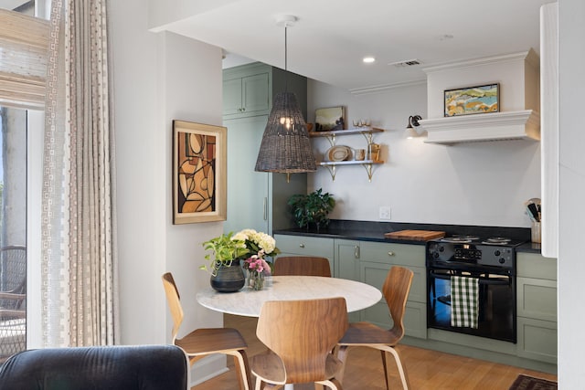 kitchen with a healthy amount of sunlight, green cabinetry, black range with electric cooktop, and visible vents