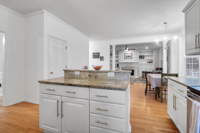 200 Oak Point Landing Dr, Mount Pleasant, SC 29464 - kitchen with light wood finished floors, crown molding, a fireplace, open floor plan, and a chandelier