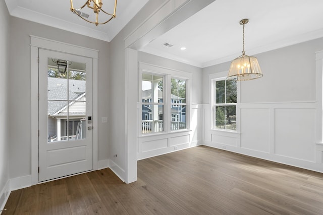 interior space with ornamental molding, wood finished floors, visible vents, and an inviting chandelier