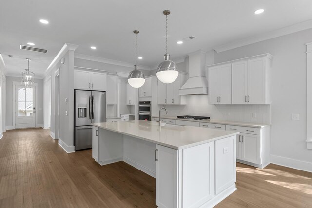 kitchen with stainless steel appliances, white cabinetry, a sink, and custom exhaust hood