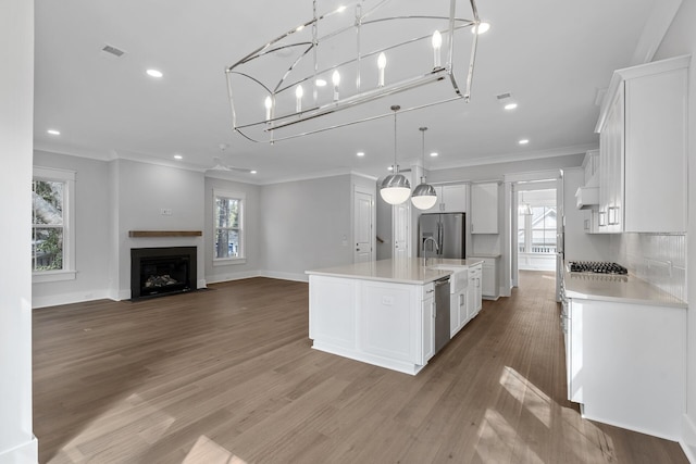 kitchen featuring open floor plan, light countertops, appliances with stainless steel finishes, and white cabinetry