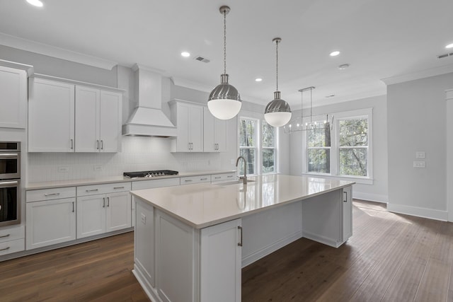 kitchen with stainless steel appliances, premium range hood, a sink, light countertops, and crown molding