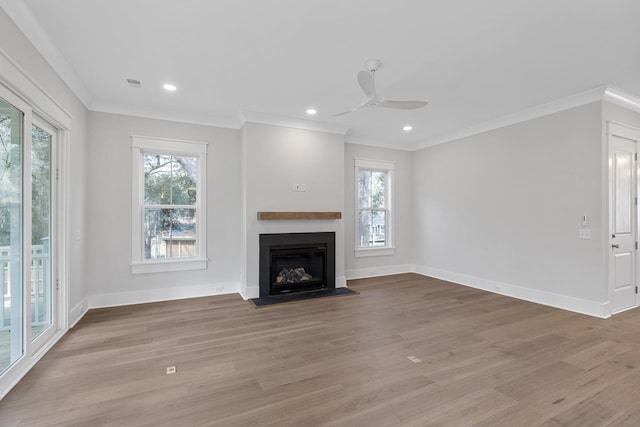 unfurnished living room with ornamental molding, light wood-type flooring, and a wealth of natural light