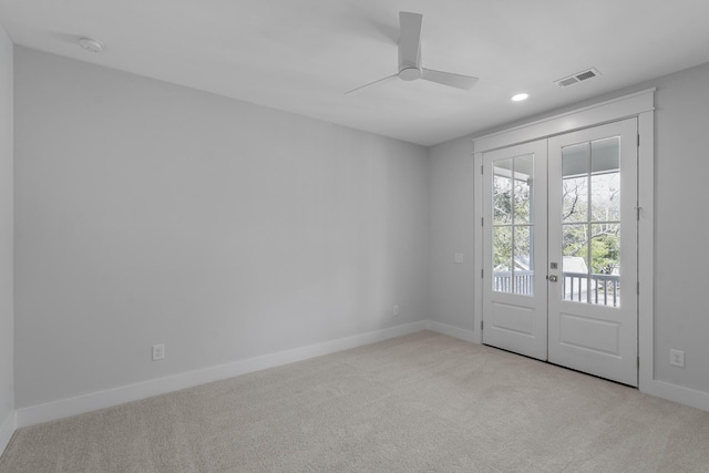 unfurnished room featuring carpet flooring, a ceiling fan, visible vents, baseboards, and french doors