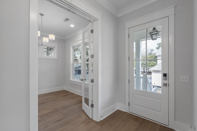 entrance foyer featuring dark wood-style floors, baseboards, visible vents, and crown molding