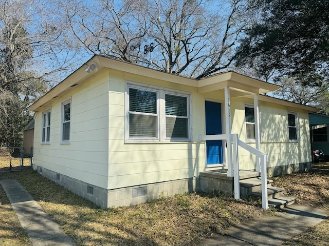 view of front of house with fence and crawl space