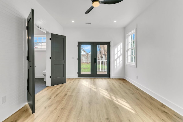 foyer entrance with ceiling fan, french doors, and light wood-type flooring