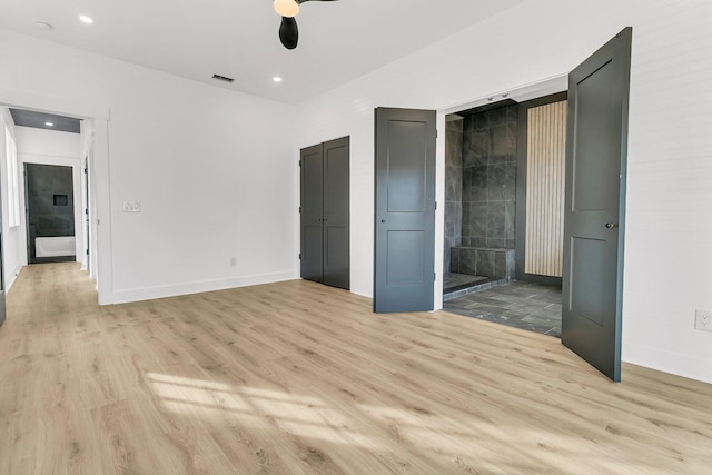 unfurnished bedroom with light hardwood / wood-style floors, ceiling fan, and ensuite bathroom